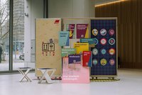 Das Bild zeigt eine Ausstellungseinheit mit verschiedenen Informationsplakaten und Tafeln, die sich mit gewerkschaftlichen Themen und Rechten befassen. Auf den Plakaten sind Begriffe wie "Frauenquote", "Mutterschutzgesetz", "Streikrecht", "Urlaubsgeld", "Allgemeines Gleichbehandlungsgesetz", "Vereinbarkeitsrichtlinie" und "Bundesteilhabegesetz" zu lesen. Jedes Plakat ist mit einem QR-Code versehen, der zu weiterführenden Informationen führt. Die Einheit ist mit dem Logo des Deutschen Gewerkschaftsbunds (DGB) gekennzeichnet und zielt darauf ab, die Vielfalt und die Errungenschaften der Gewerkschaften hervorzuheben, wie der Slogan "Für Vielfalt erkämpft" illustriert. Im Hintergrund sind runde Informationsschilder zu sehen, die weitere gewerkschaftliche Themen und Statistiken darstellen. Die gesamte Präsentation ist in einem modernen und ansprechenden Design gehalten, das die Aufmerksamkeit auf wichtige soziale und arbeitsrechtliche Themen lenkt.